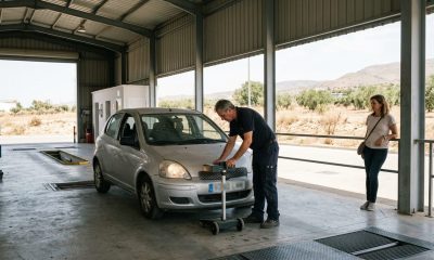 Inspector checking a car's headlights in an inspection hall on the Costa del Sol while the owner waits