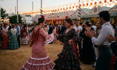 Women in flamenco dresses dancing sevillanas under lanterns at an Andalusian feria