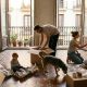 Parents with a toddler, a young daughter and a dog unpacking moving boxes in a sunny Spanish apartment