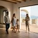 Young family and an estate agent look at the sea view from the terrace of an empty white villa near Estepona