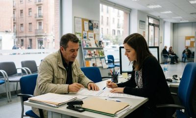 Middle-aged man going through unemployment benefit documents with an adviser at an employment office in Zaragoza