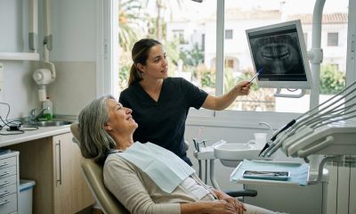 Retired woman in a dentist chair listening as a dentist explains an X-ray in a bright clinic on the Costa del Sol