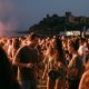 Friends dancing at an open-air summer concert by the sea on the Costa del Sol at dusk