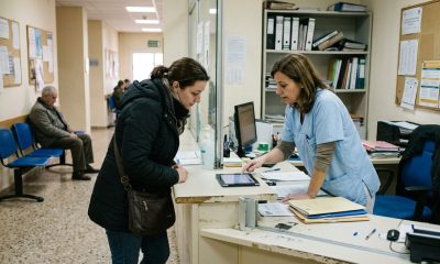 Nurse helping a resident with her digital health record at a Spanish health centre reception