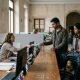Young couple with a toddler handing documents to a clerk at a Spanish town hall desk to register on the padrón