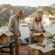 Retired couple unpacking moving boxes on the terrace of a whitewashed village house near Nerja at sunset