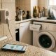 Smart plug and smartphone energy app on a kitchen counter in a bright Spanish apartment