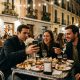 Group of friends at a tapas bar terrace in Madrid at night splitting the bill on a smartphone