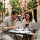 Couple at a café in Spain reviewing passports and visa documents