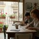 Woman sealing a postal vote envelope at her kitchen table in a sunny Spanish apartment while her son watches