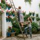 Grandmother and teenage granddaughter watering potted geraniums in a whitewashed Córdoba patio in May