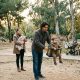 Young father pushing a toddler on a swing while the mother holds a newborn in a park in Valencia